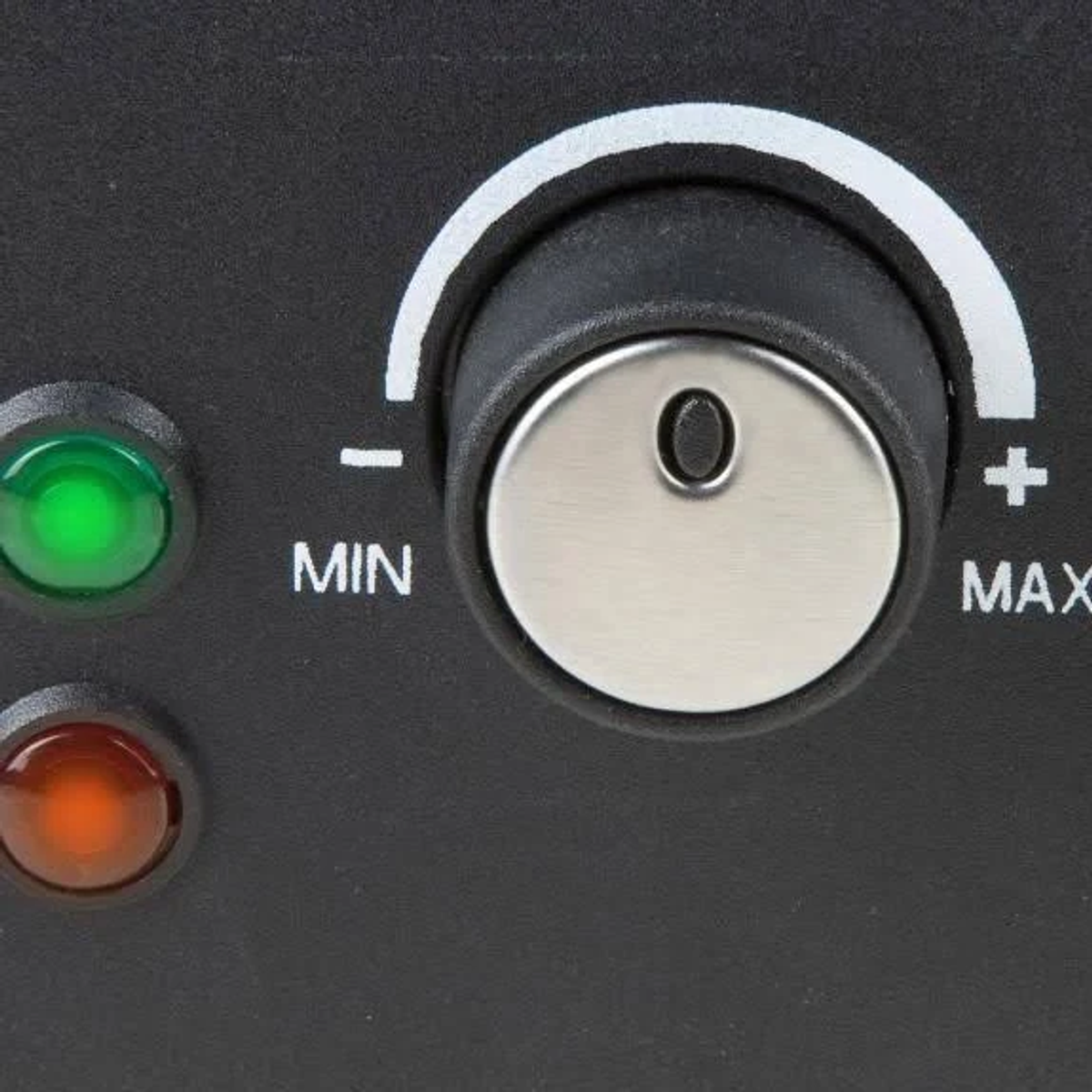 Primer plano de un dispositivo negro con un dial y luces indicadoras verdes y rojas.