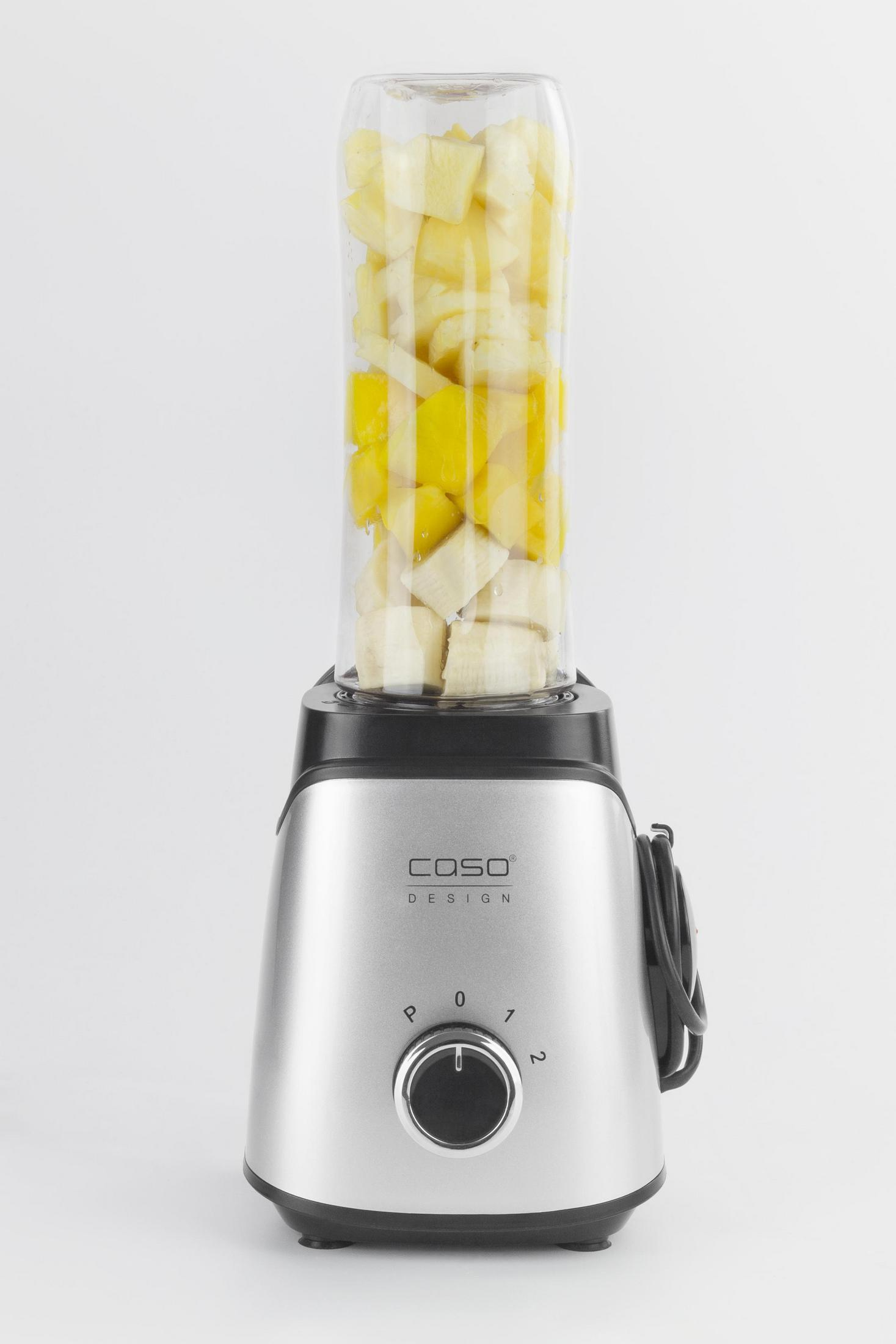 Silberner Mixer mit Glasbehälter, gefüllt mit gehackten gelben und weißen Früchten.