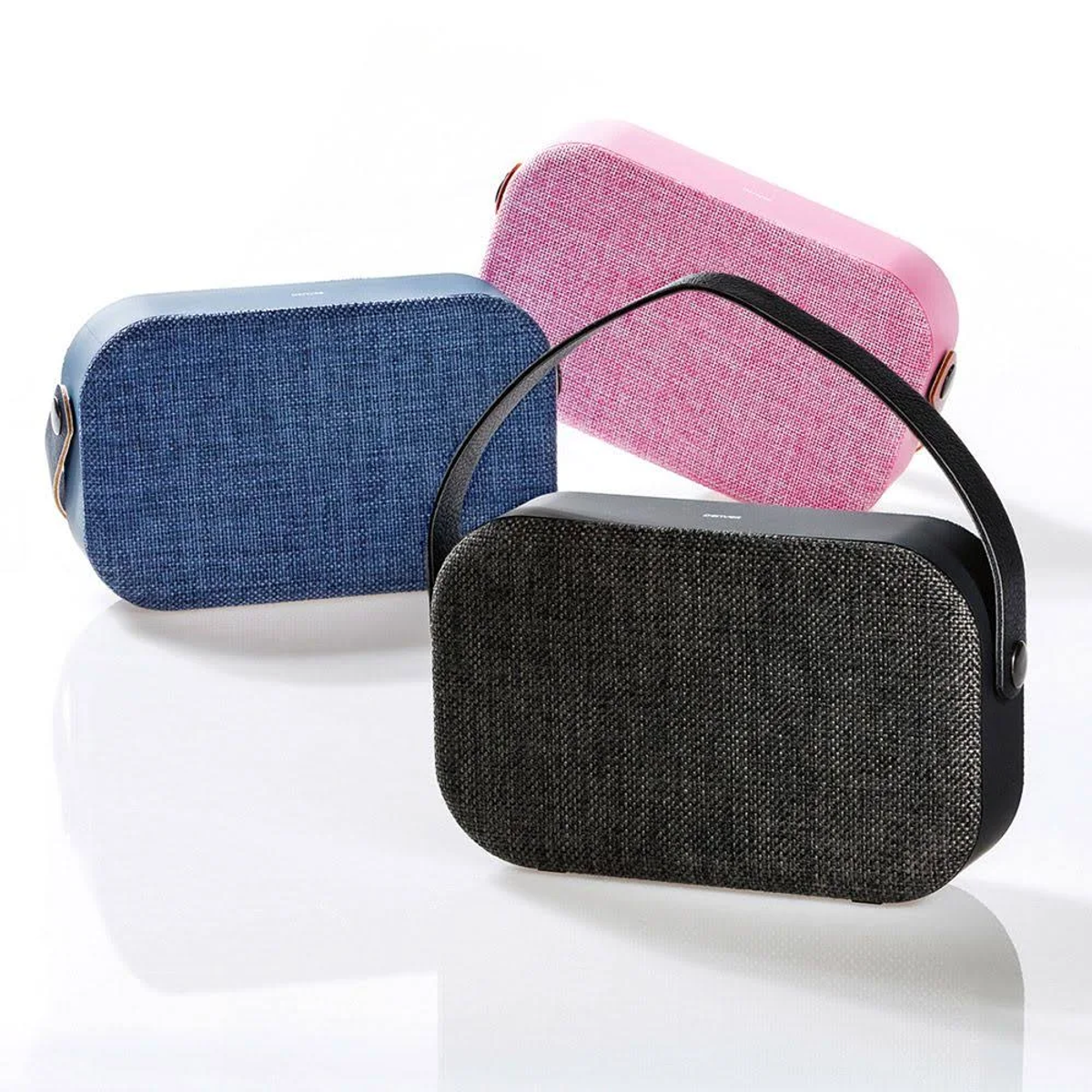 Tres altavoces portátiles en azul, rosa y negro, con asas.