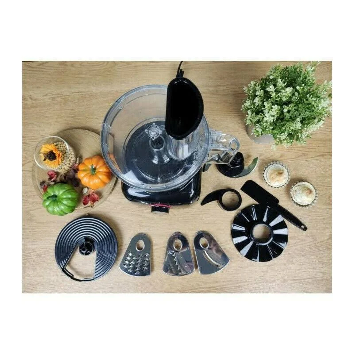 Varios accesorios de cocina, incluyendo un procesador de alimentos y una variedad de cuchillas de corte.
