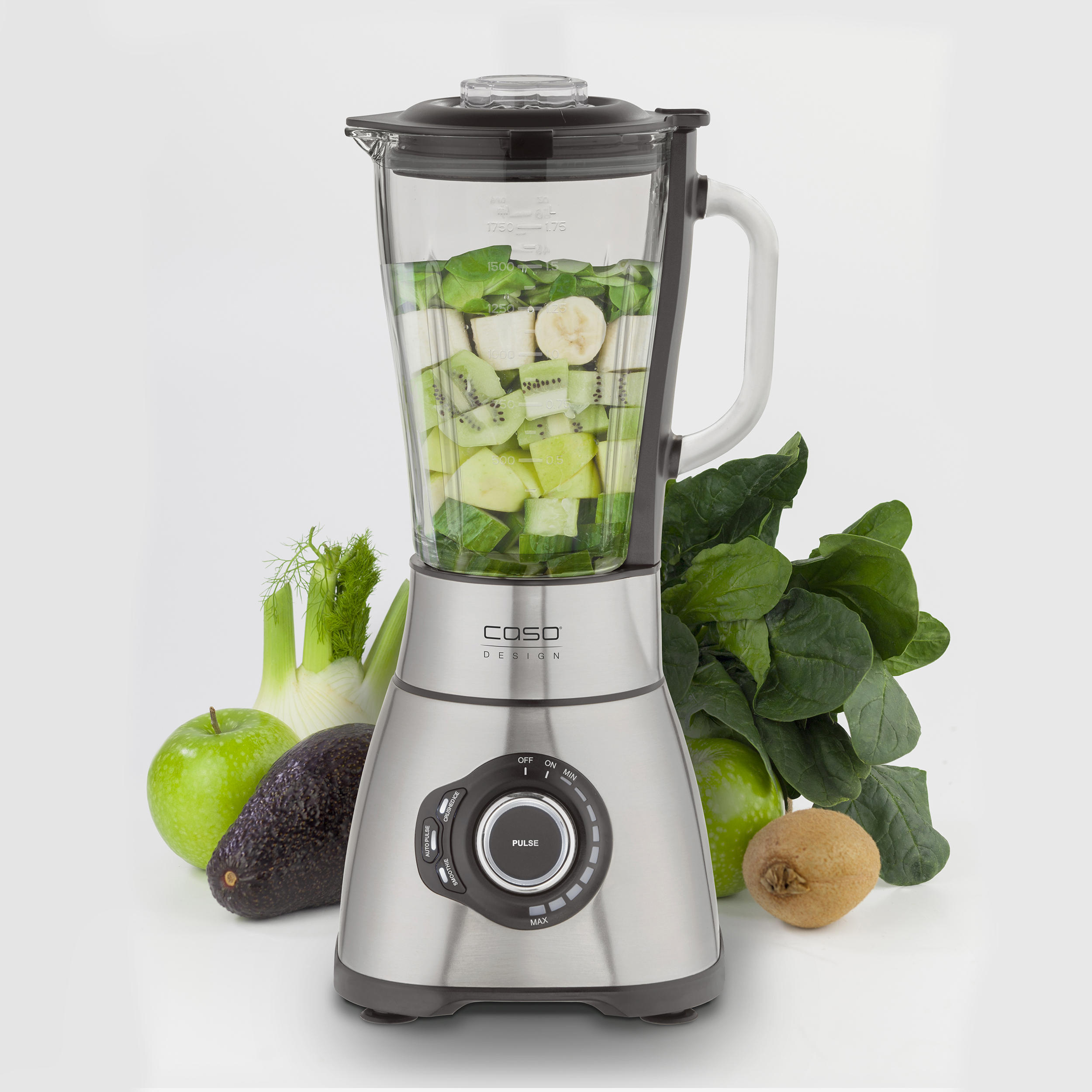 Mixer mit grünen und weißen Zutaten, umgeben von Obst und Gemüse, Edelstahlbasis.