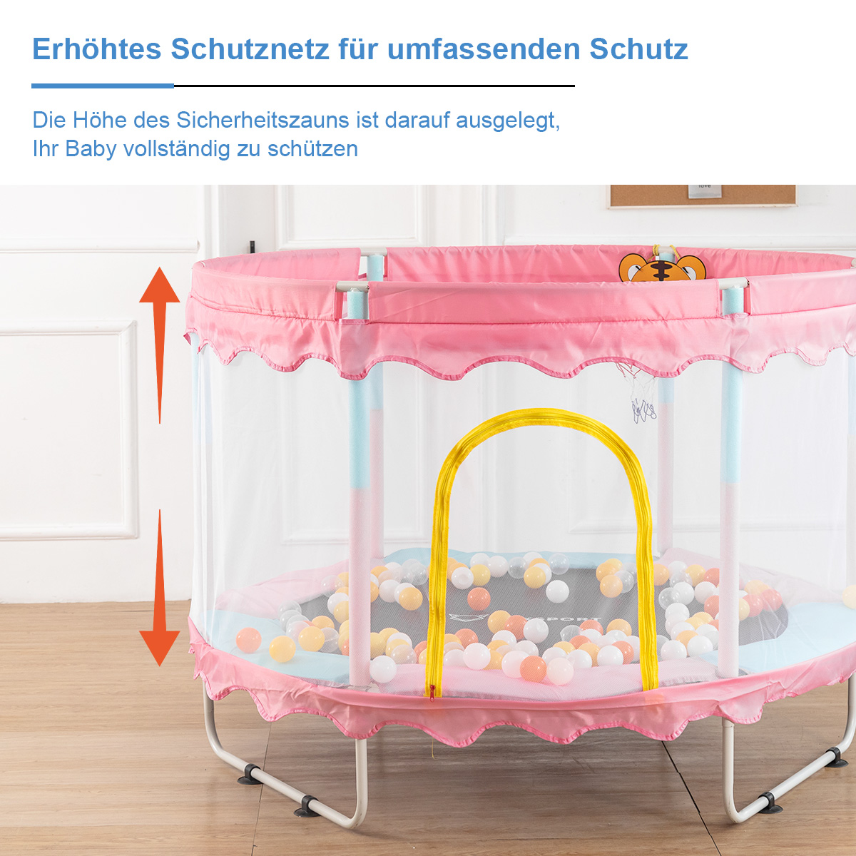 Eine rosa-weiße Hüpfburg mit Netzseiten, einem gelben Bogen und bunten Bällen im Inneren.