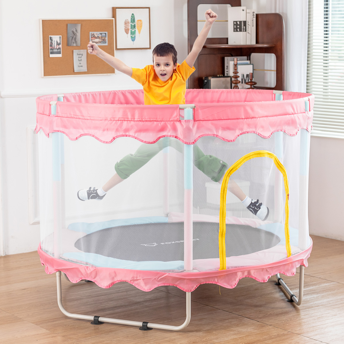 Ein Kind springt in einem rosa und blauen Trampolin mit gelbem Bogen und Netzseiten.