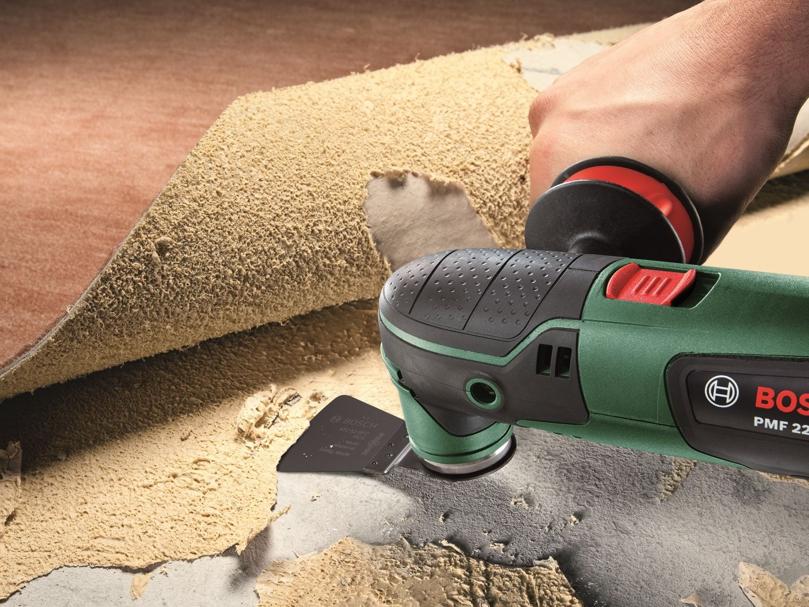 Ręka używająca elektronarzędzia do usuwania materiału z powierzchni. Powierzchnia jest uszkodzona.