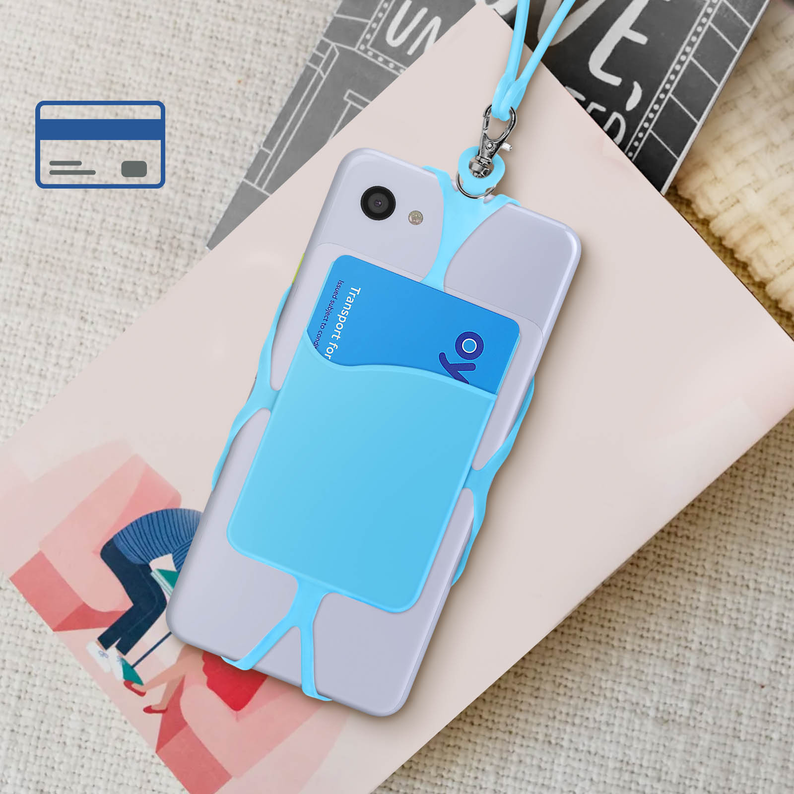 Un supporto per telefono blu con una carta di credito in un telefono, su un libro, su una superficie a fantasia.