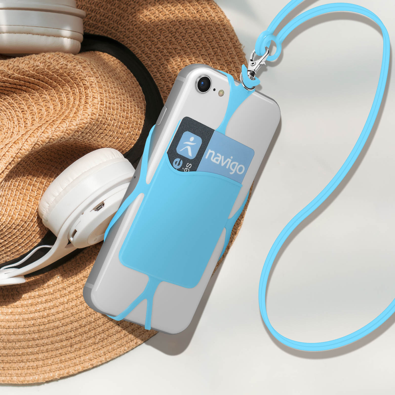 Un telefono in una custodia blu con un cordino, un cappello e delle cuffie. Sfondo bianco.