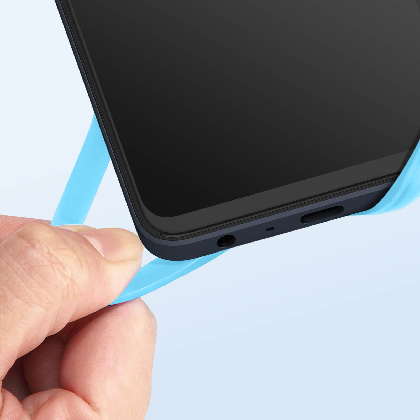 Mano che stacca la pellicola protettiva blu da uno smartphone nero.