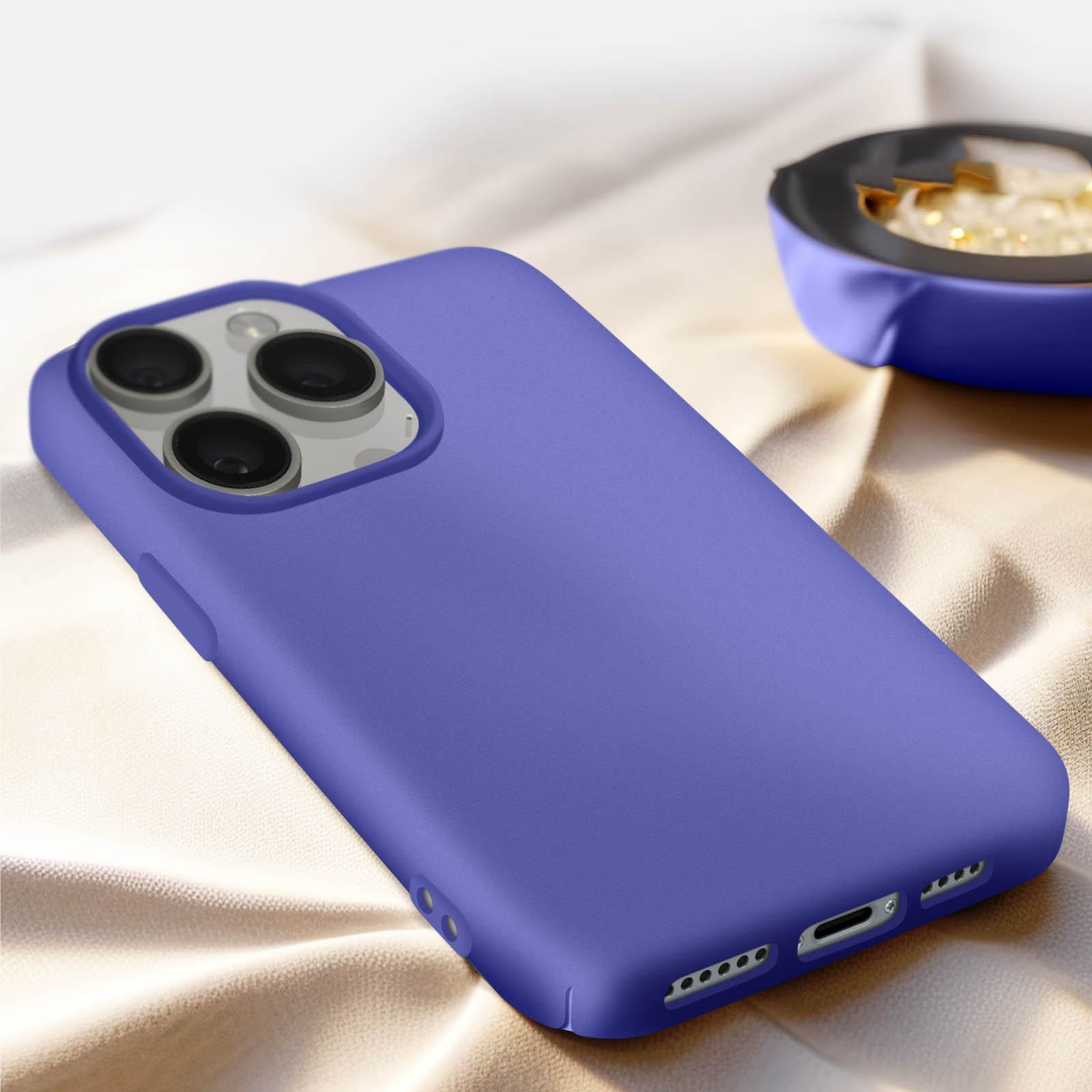 Custodia per telefono viola con tre obiettivi della fotocamera su superficie beige.