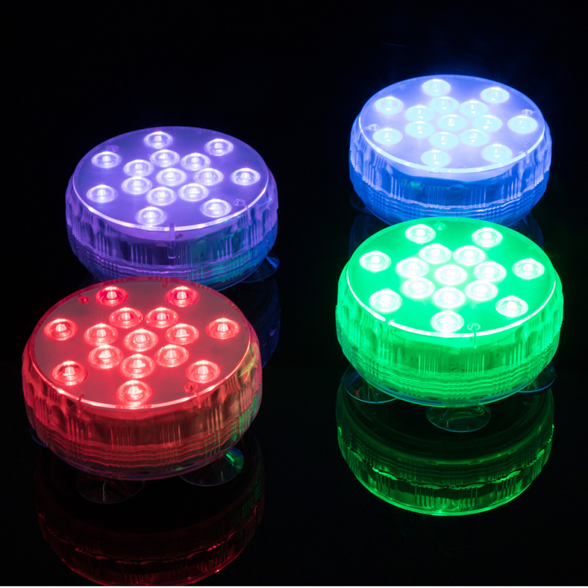 Vier Unterwasserlichter, jedes mit einer anderen Farbe: lila, blau, rot und grün. Rund mit Saugnäpfen.