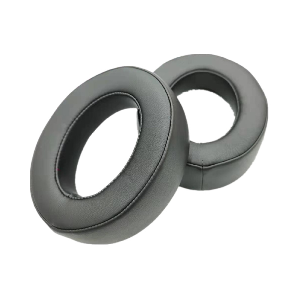 Dwie czarne poduszki na uszy do słuchawek. Białe tło.