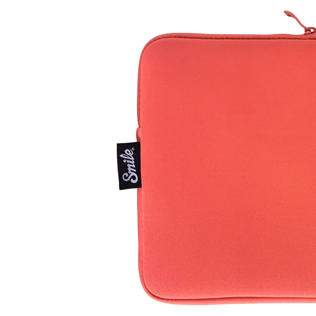 Primer plano de una funda naranja para portátil con una etiqueta negra que dice 'Smile'.