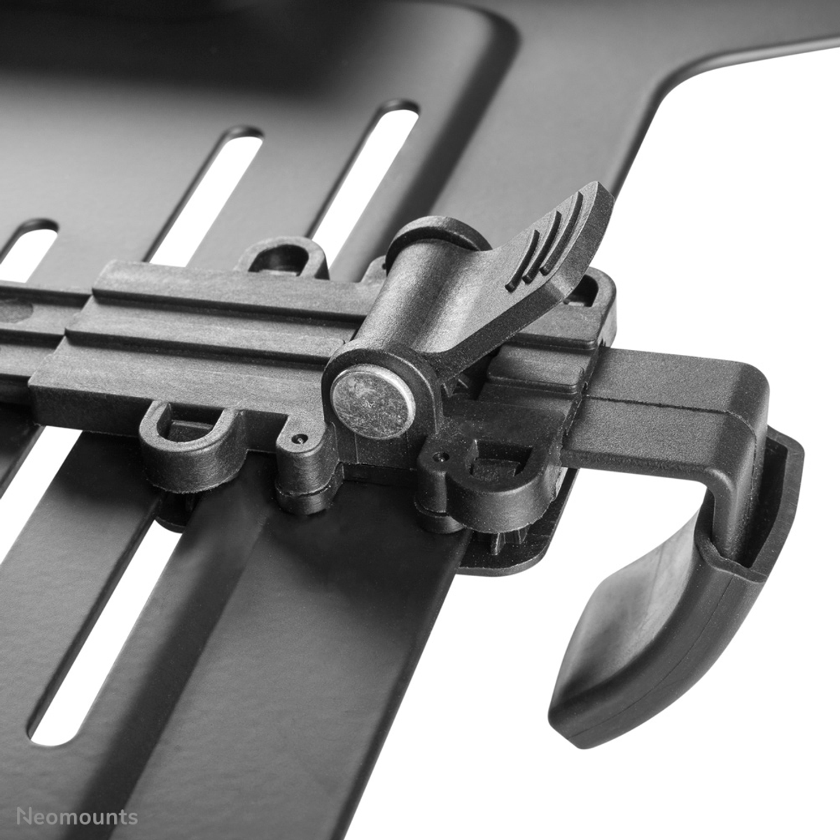 Close-up of a black clamp with a lever and metal pin on a mounting plate.