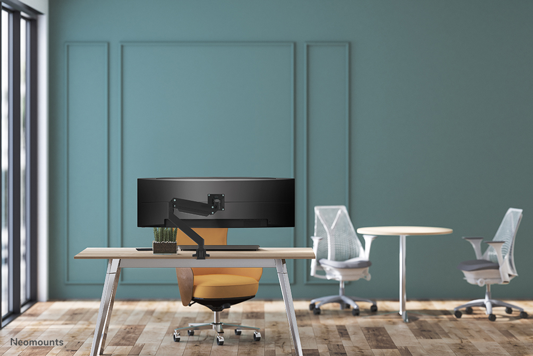 Modern office space with a desk, monitor, two chairs, and a small table.