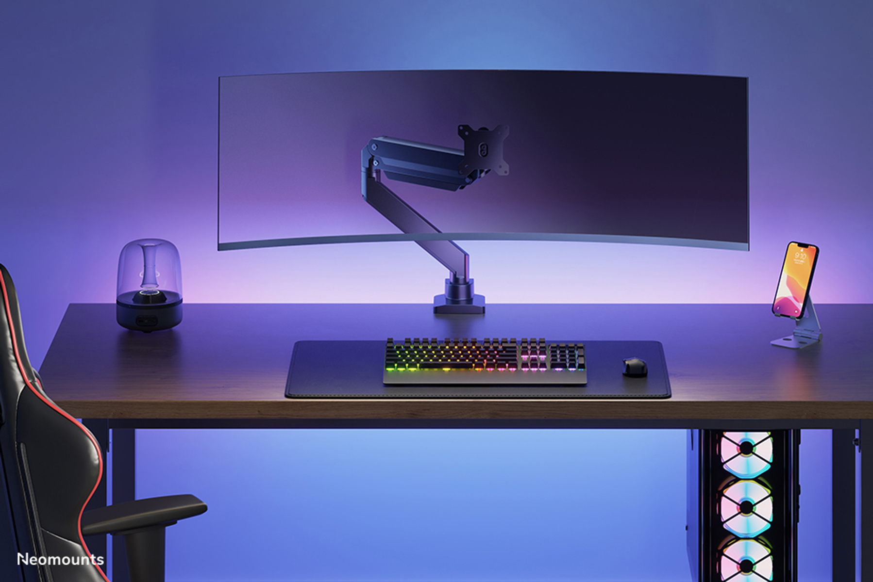 A desk setup featuring a curved monitor, keyboard, mouse, and lighting.