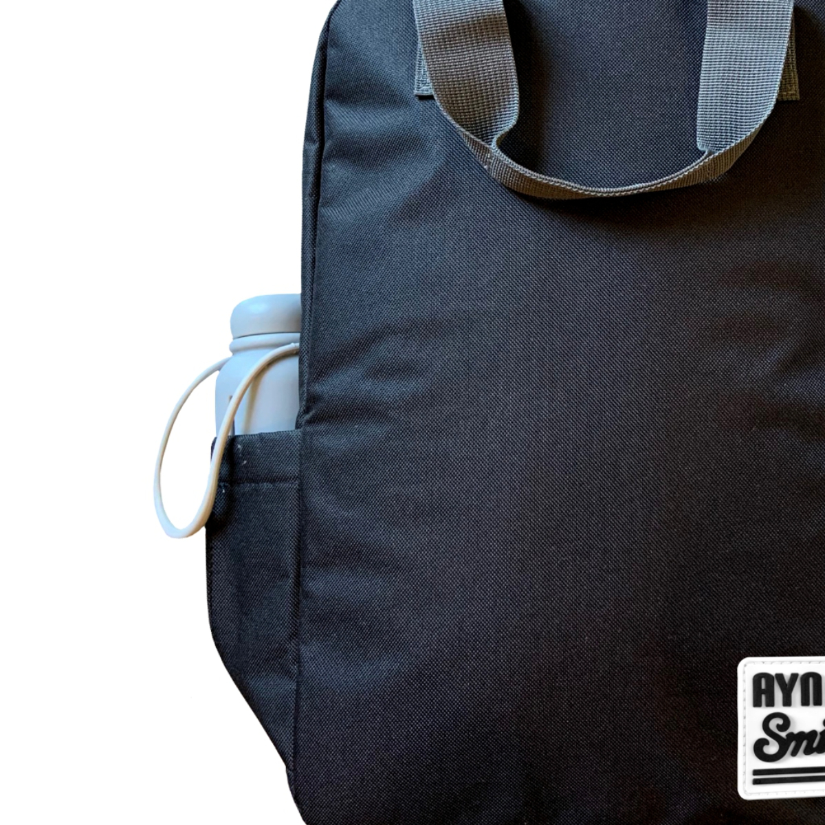 Bolso tote negro con asa gris y botella de agua en bolsillo lateral, aislado sobre blanco.