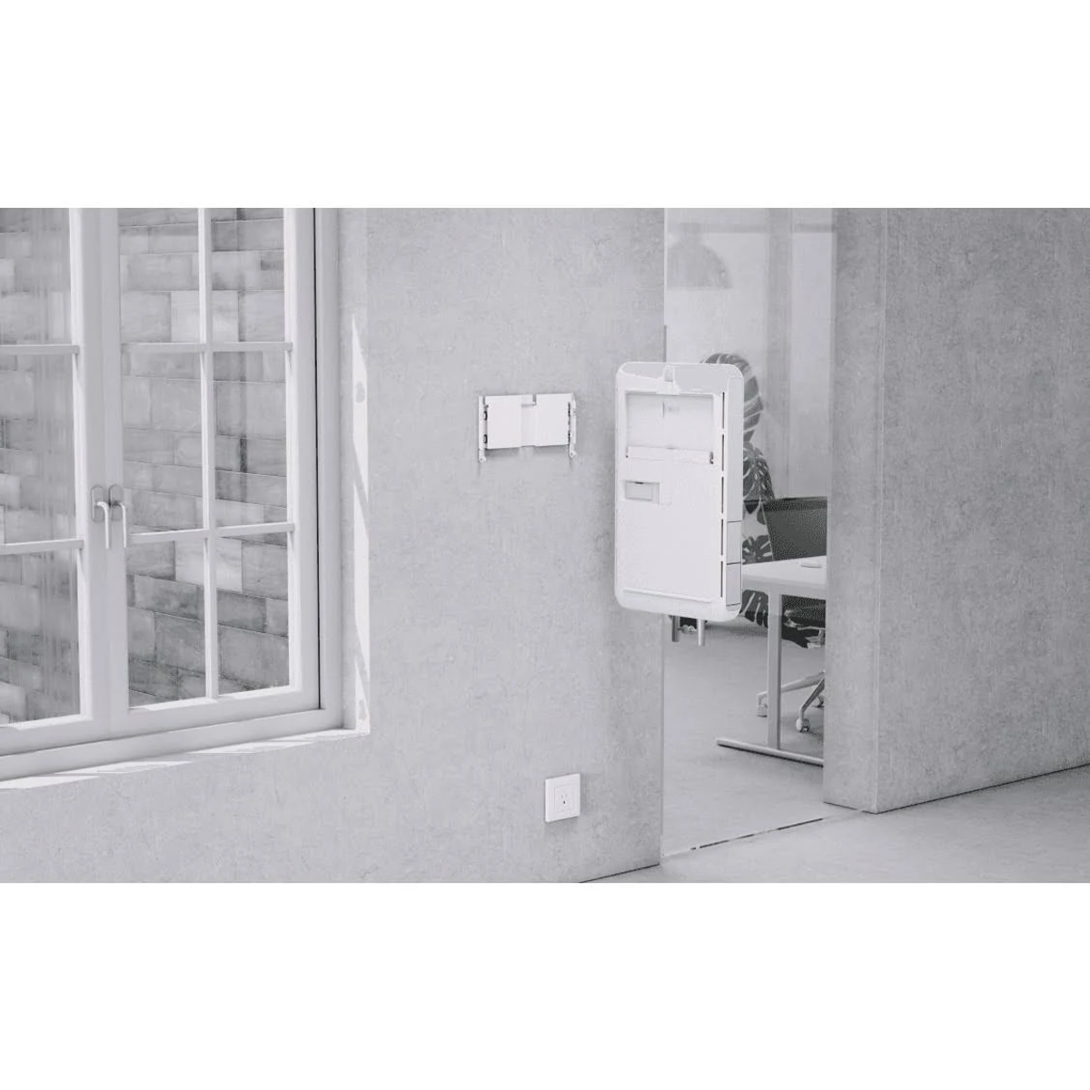 Weiße Elektrogeräte an einer grauen Wand, mit einem Fenster und einer Tür im Hintergrund.
