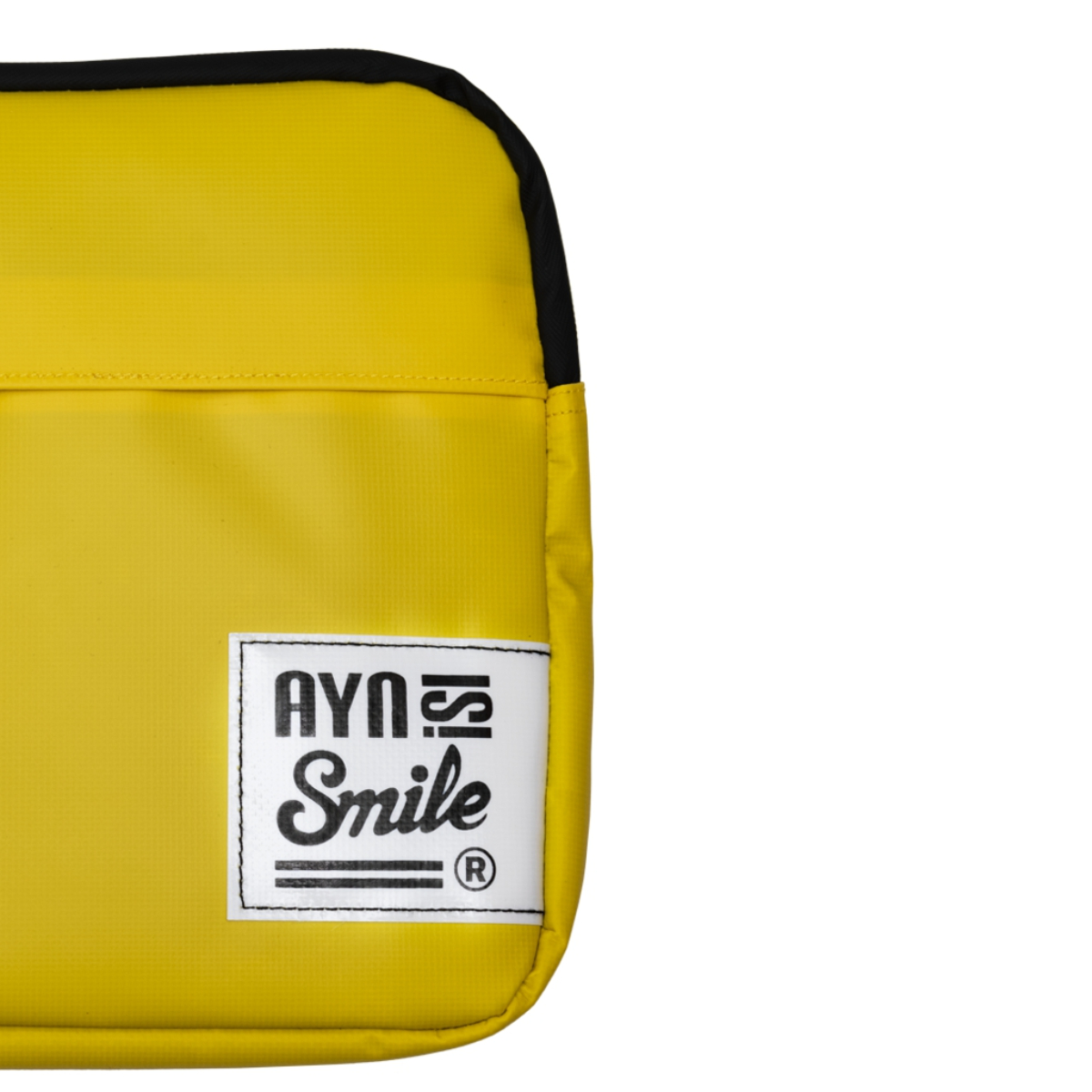 Bolso bandolera amarillo con una etiqueta blanca, 'AYNS Smile'.