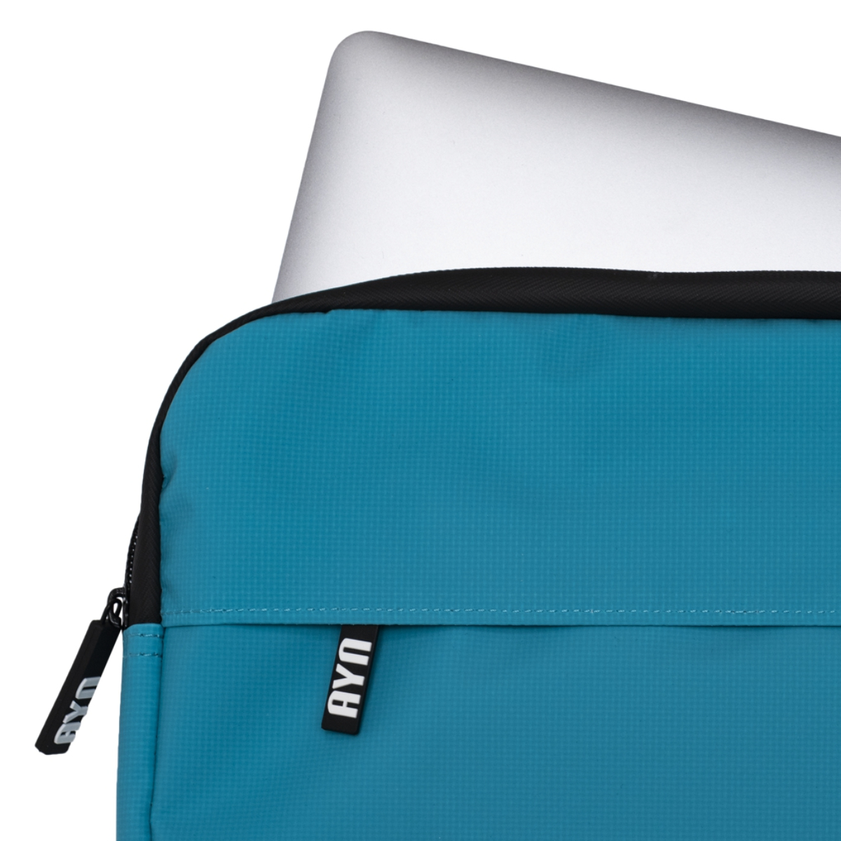 Funda para portátil turquesa con portátil plateado. Cremallera negra y etiquetas AYM.