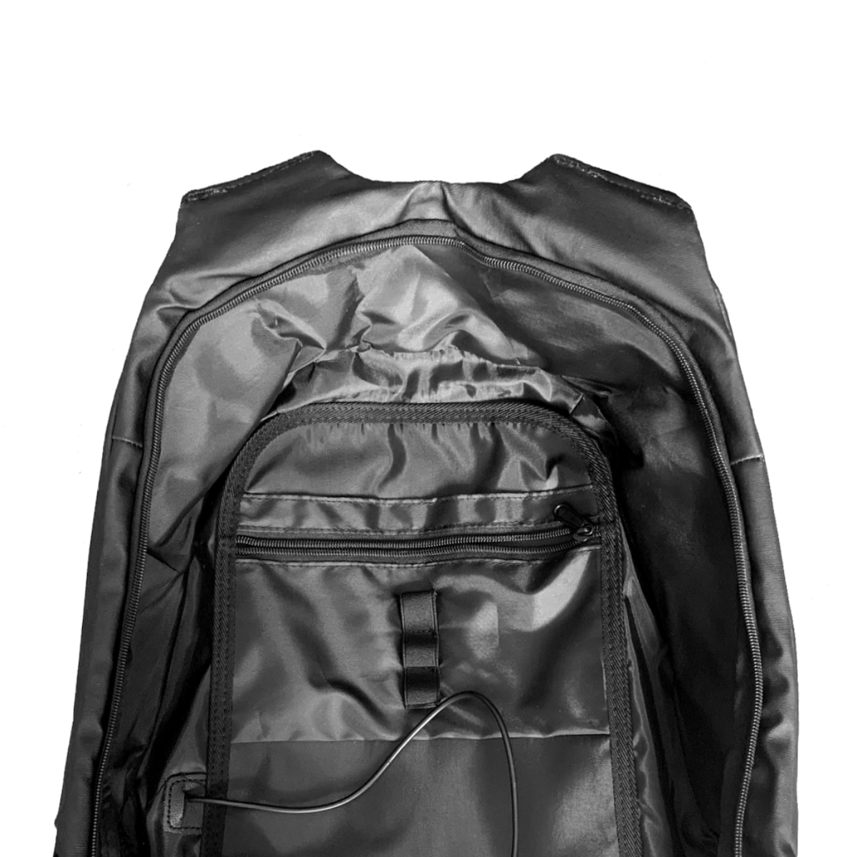 Interior de mochila negra. Se ven bolsillos con cremallera y compartimentos. Un cable sale de un bolsillo.
