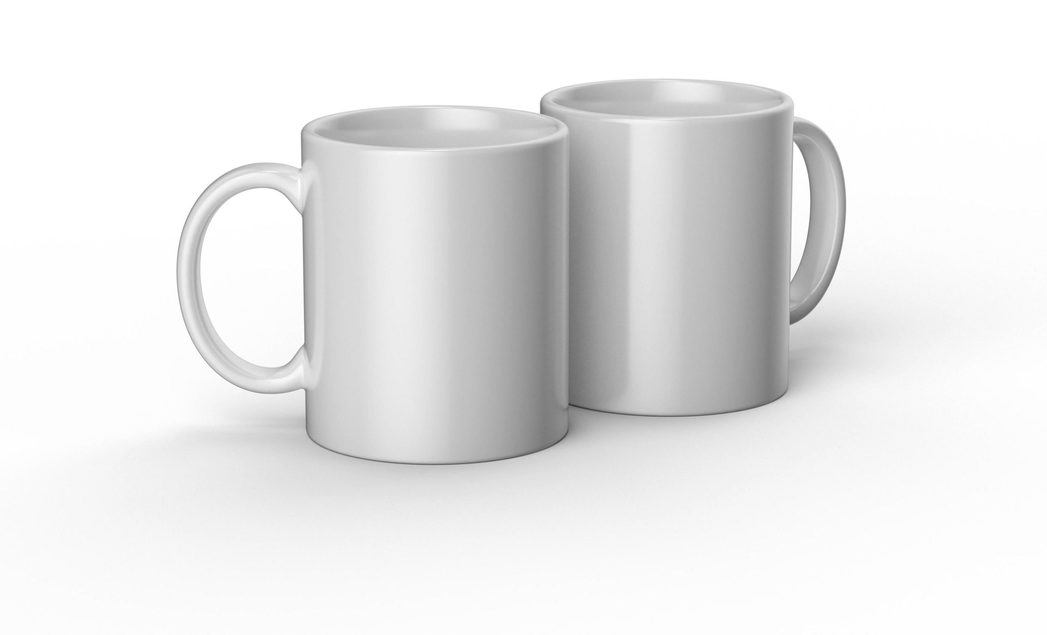 Dos tazas de cerámica blanca sobre una superficie blanca. Ambas tienen asas y están una al lado de la otra.