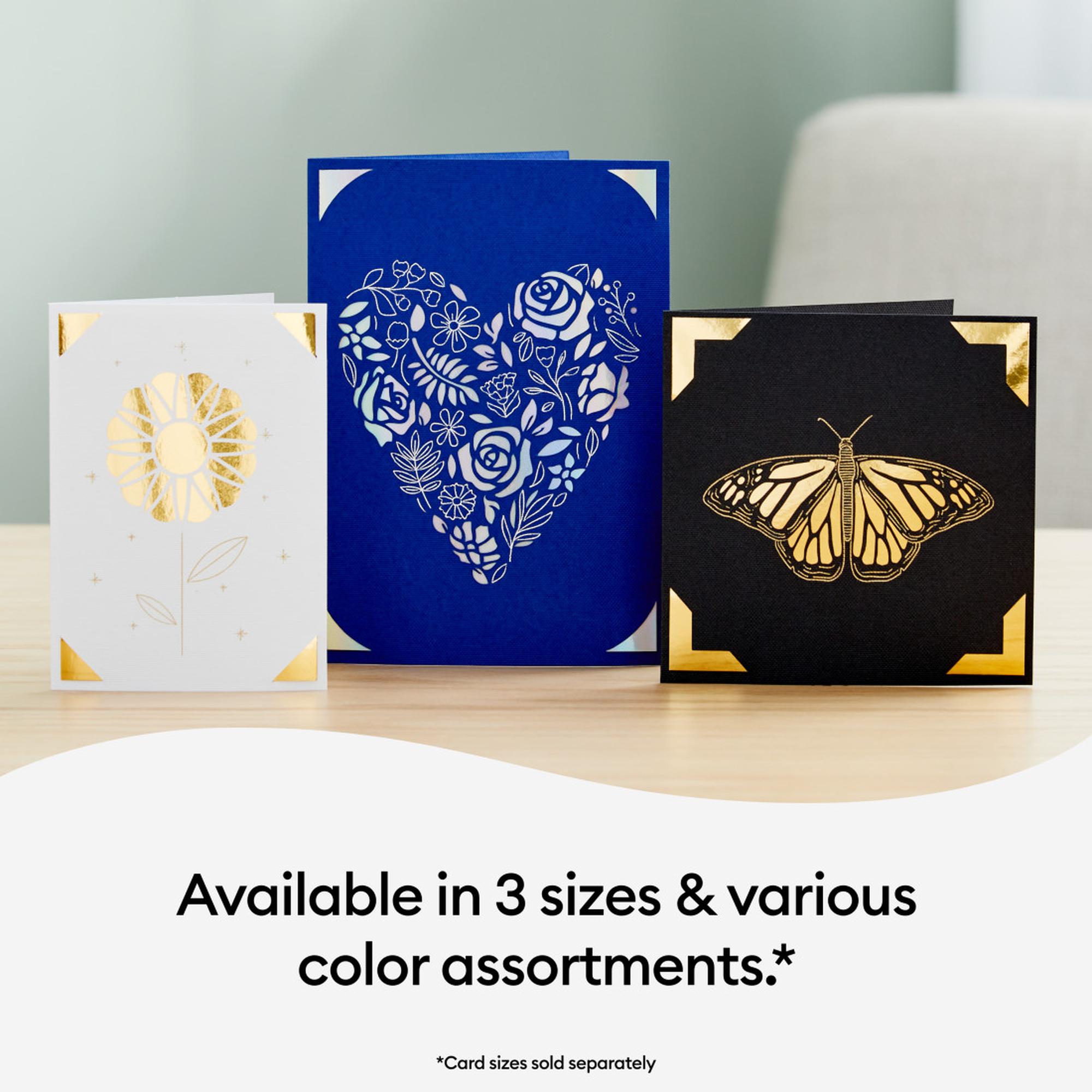 Drei Pop-up-Karten: weiße Blume, blaues Herz mit Blumen und schwarzer Schmetterling. Alle mit Goldakzenten.