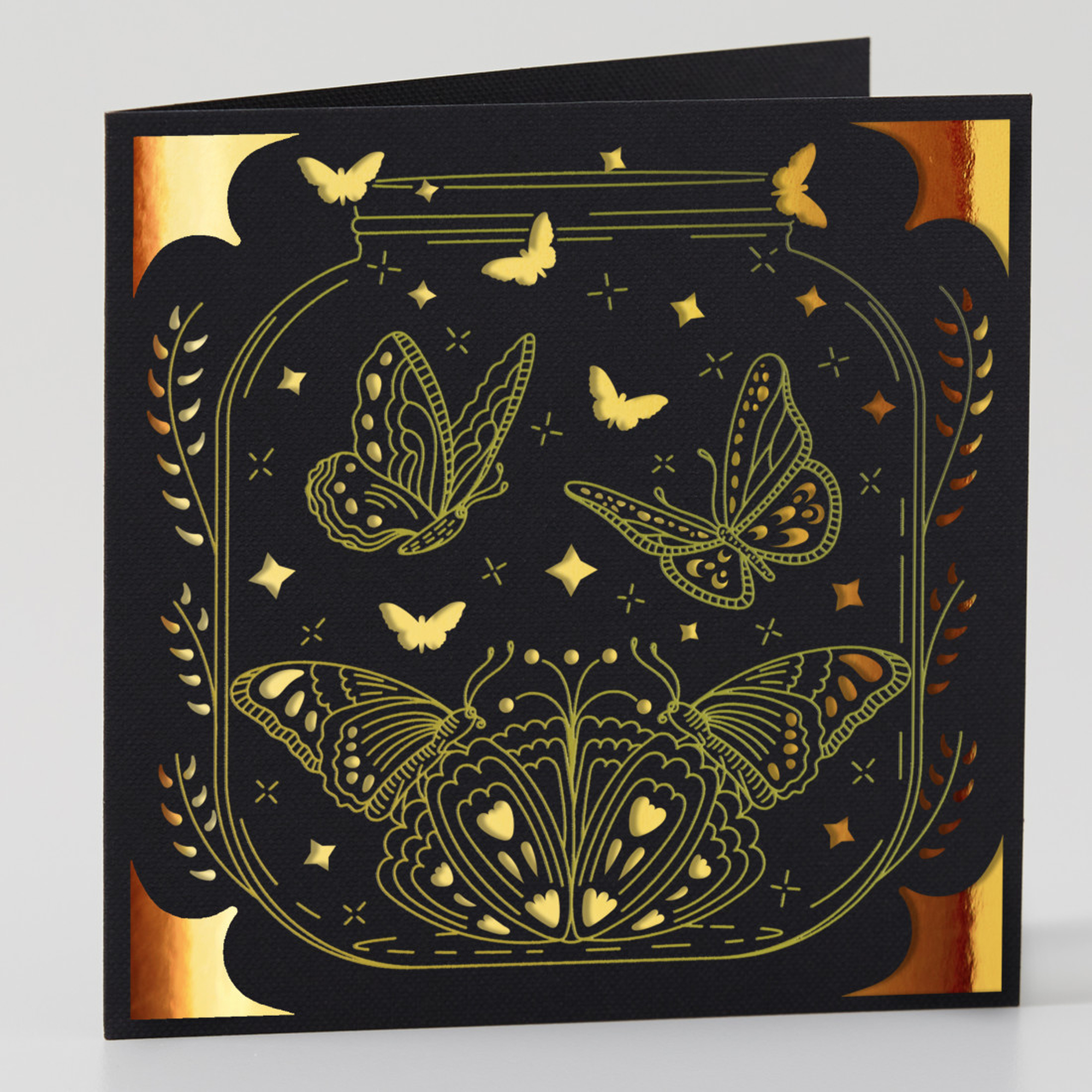 Schwarze Karte mit Schmetterlingen und goldenen Akzenten. Schmetterlinge ausgeschnitten. Schwarzer Hintergrund.