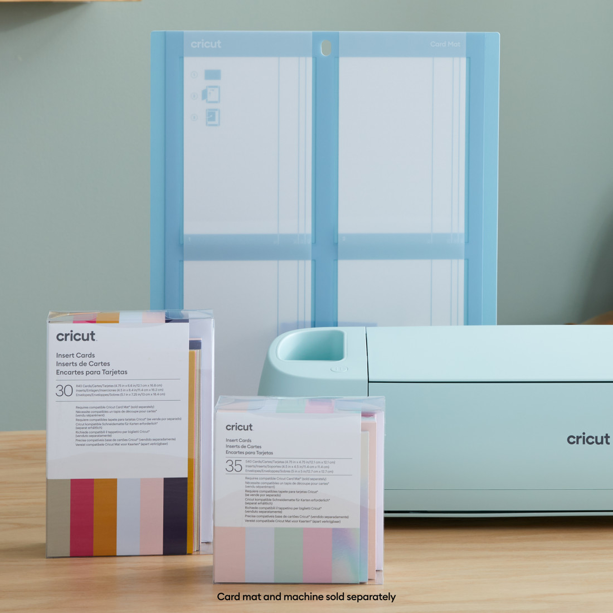 Cricut Einlegekarten, Kartenmatte und Maschine mit Verpackung auf hellblauem Hintergrund.
