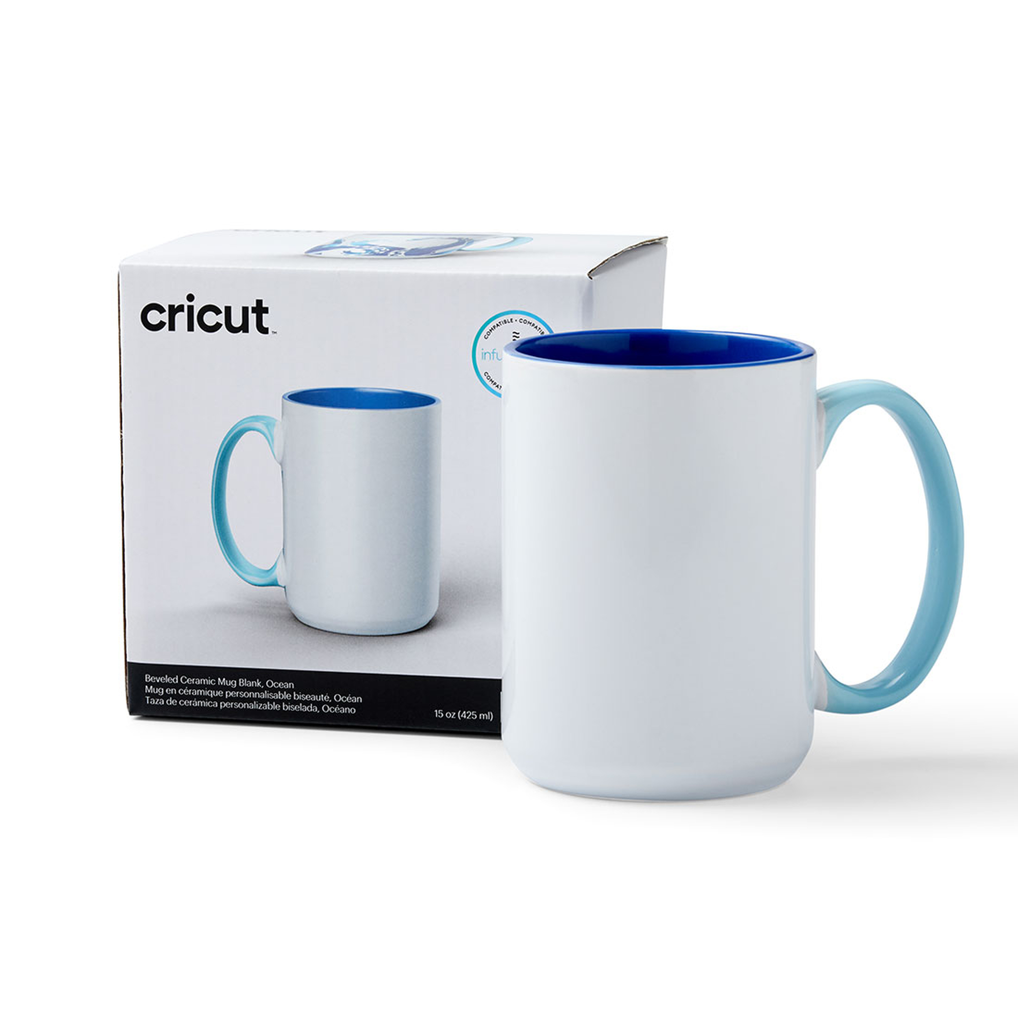 Weißer Becher mit blauem Innenraum und Griff, in seiner Box. Text: Cricut Becher.