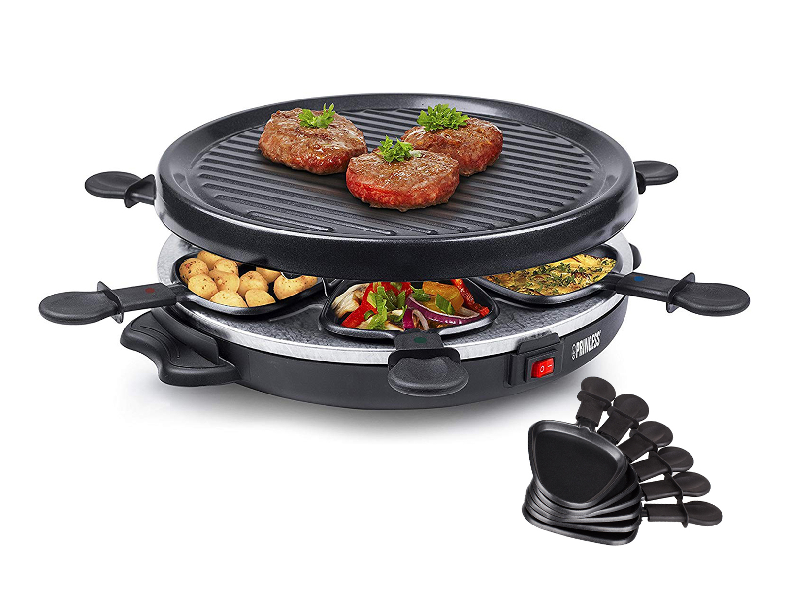 Raclette-Grill mit Essen. Enthält eine Grillplatte, Pfannen und einen schwarzen Spatel.