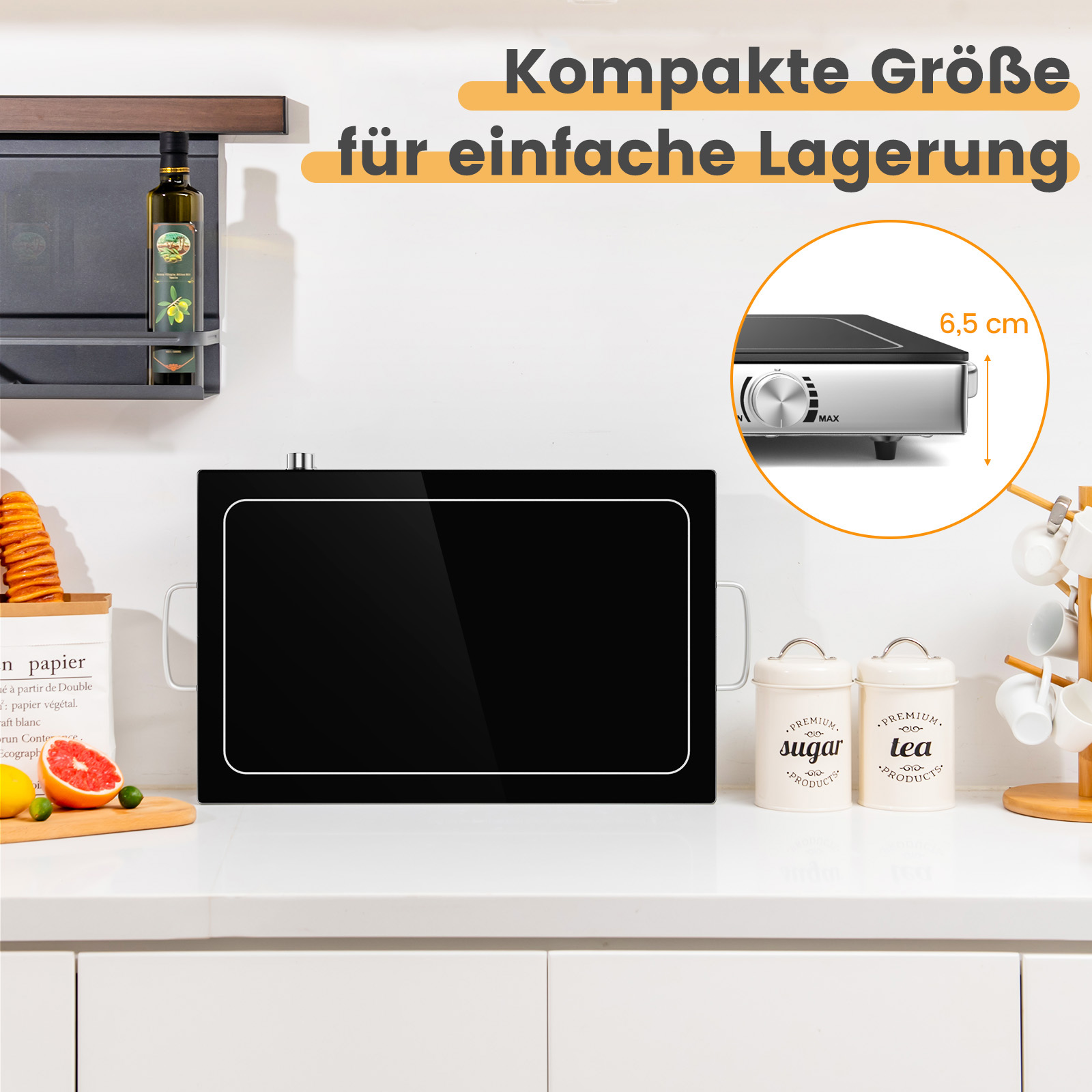 Ein schwarzes Induktionskochfeld auf einer weißen Arbeitsplatte. Ein Ölbehälter und andere Gegenstände befinden sich in der Nähe.