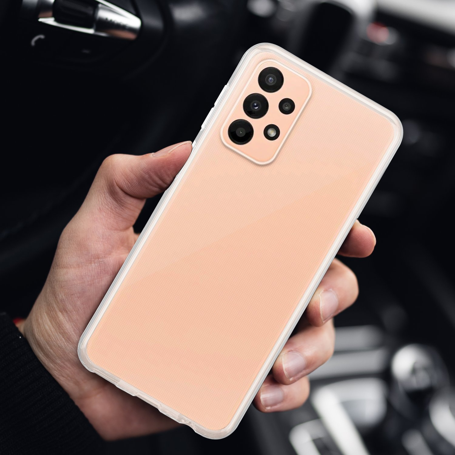 Mano che tiene un telefono color pesca. Il telefono ha più fotocamere.