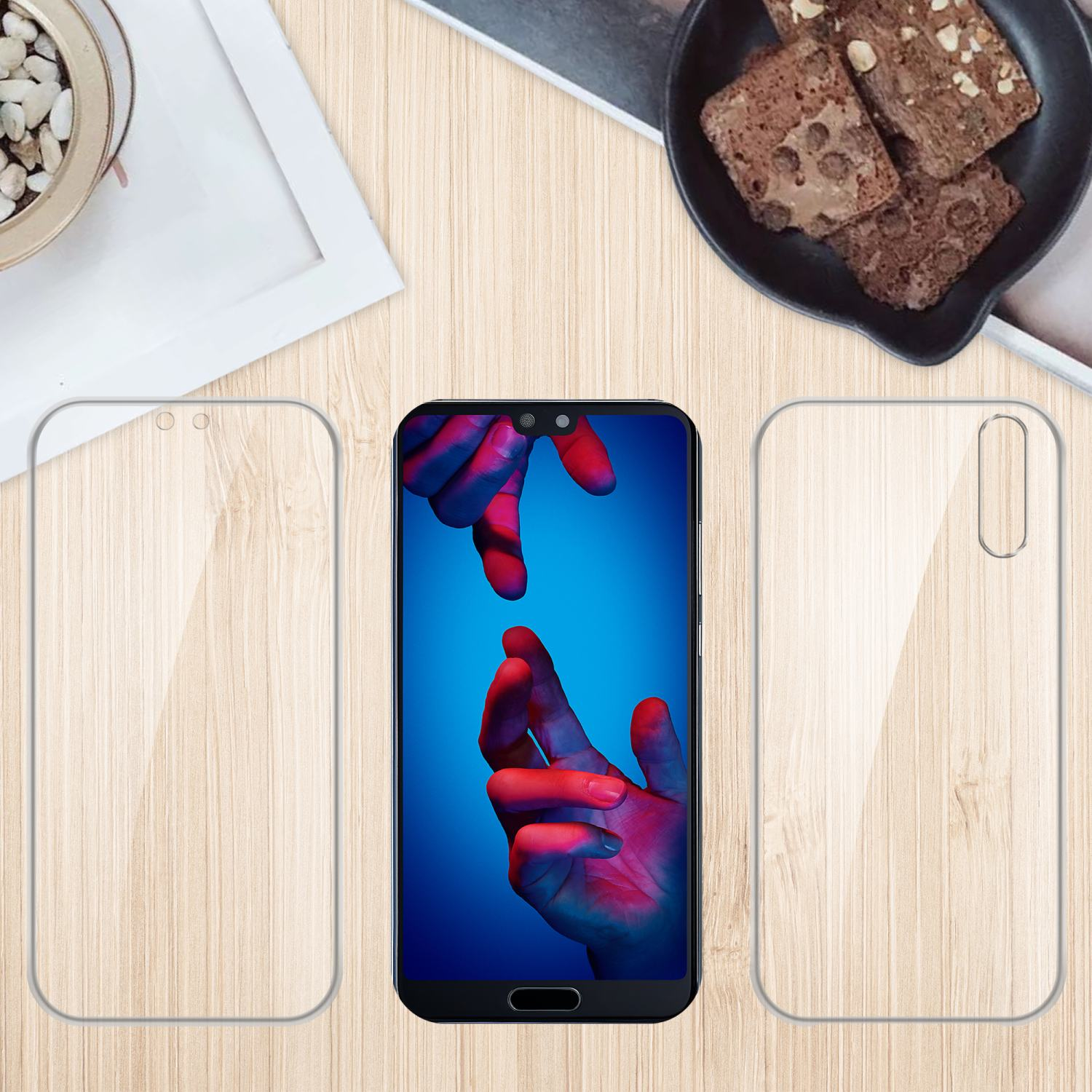 Telefono su tavolo di legno con protezione schermo e custodia. Brownies e pianta sullo sfondo.