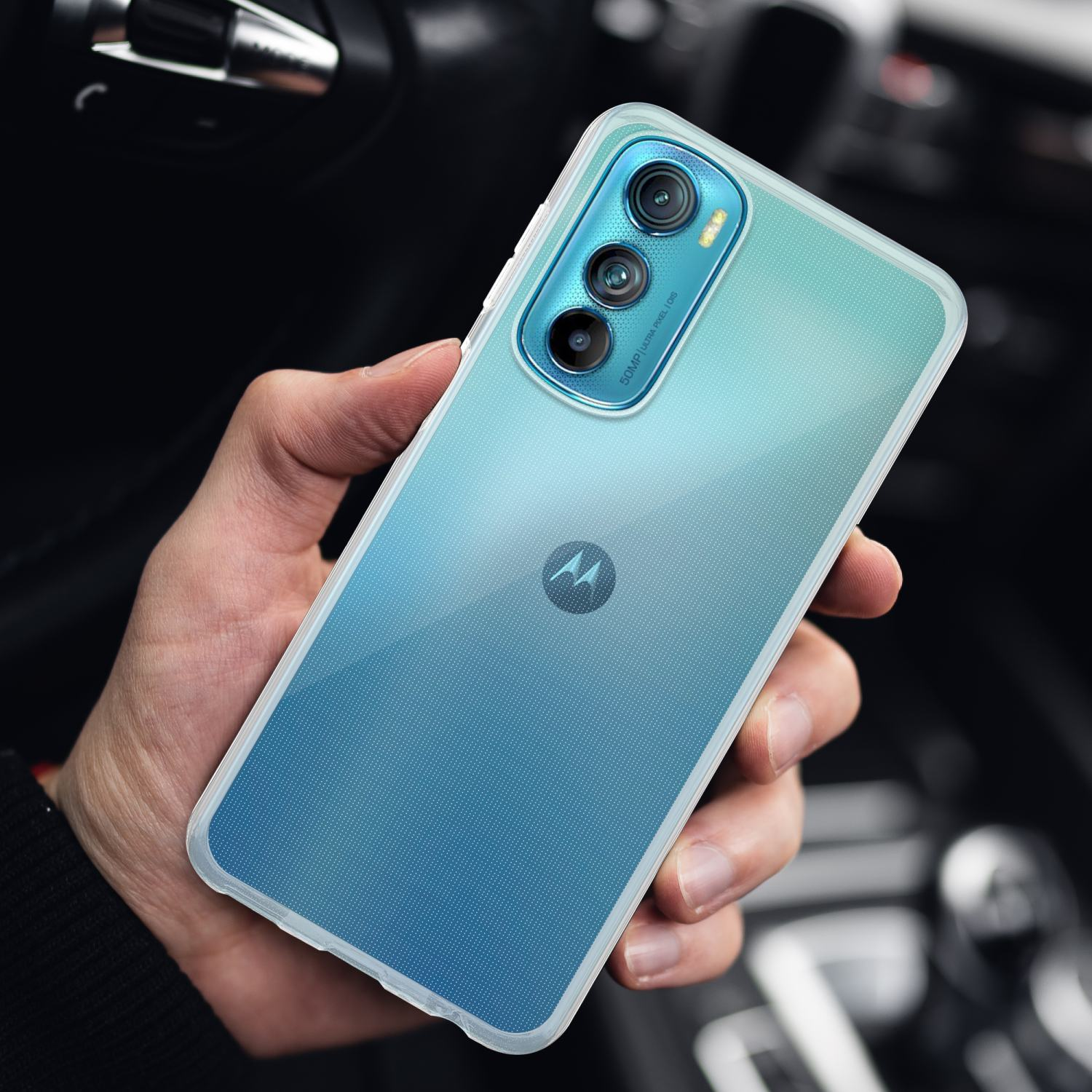 La mano di una persona che tiene una custodia per telefono con retro blu sfumato e cornice trasparente.