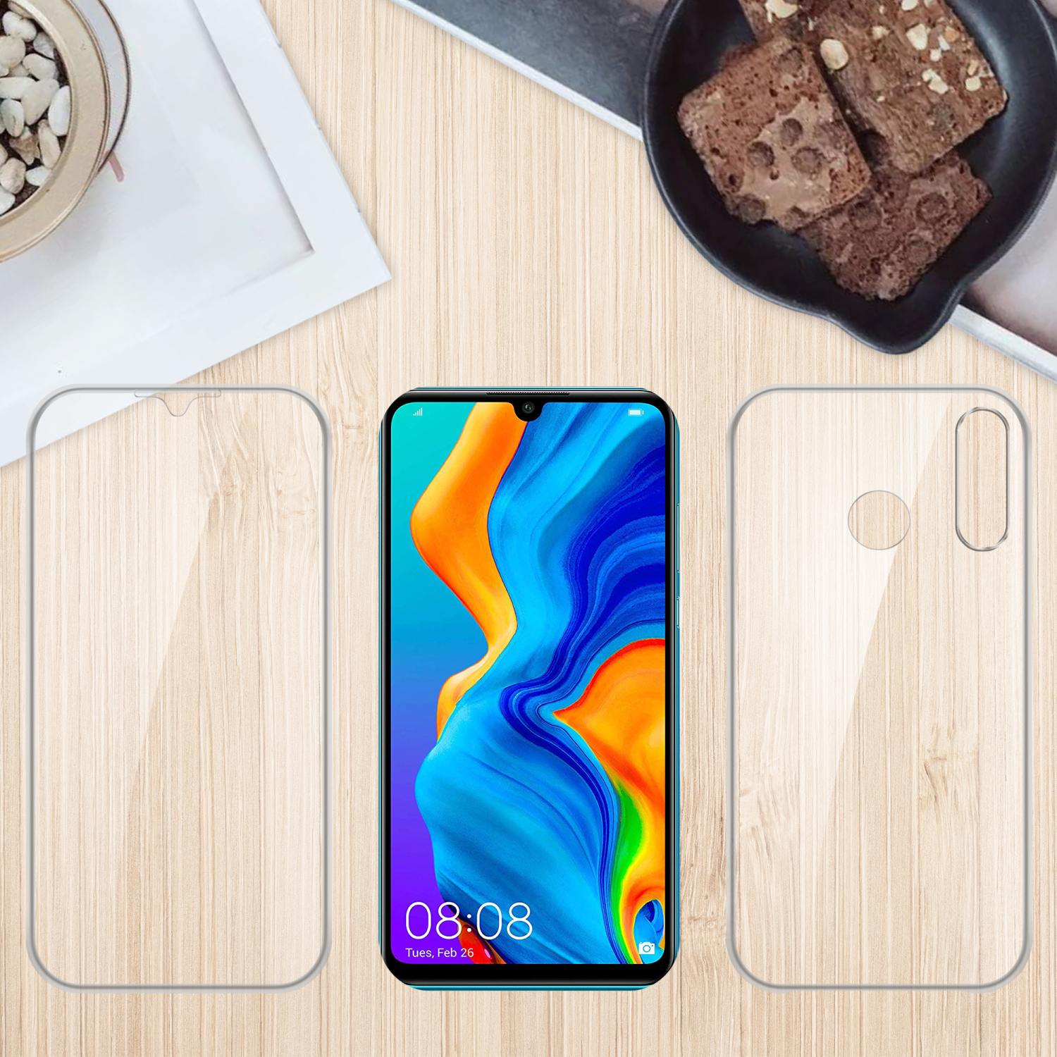 Telefon, Displayschutz und Handyhülle auf einem Holztisch. Brownies und eine Pflanze im Hintergrund.