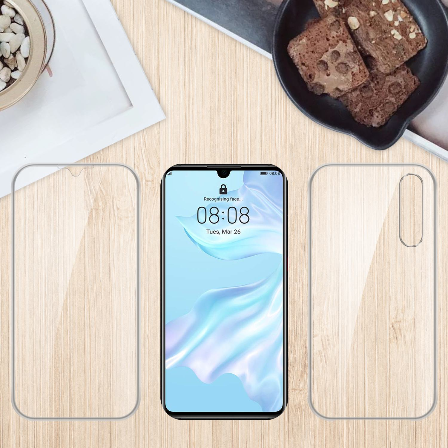 Un telefono con protezioni per lo schermo e una custodia, con un tavolo e cibo sullo sfondo.