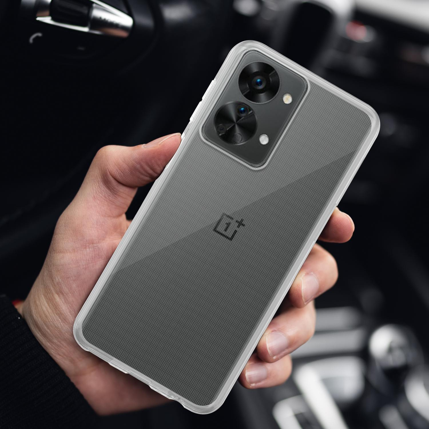 Una persona tiene in mano un telefono con una custodia trasparente. Il telefono ha una fotocamera nera ed è di colore argento.