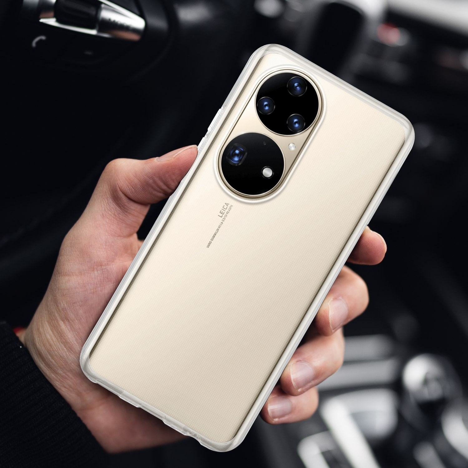 Une personne tenant un téléphone doré avec une coque transparente, montrant les lentilles de la caméra.