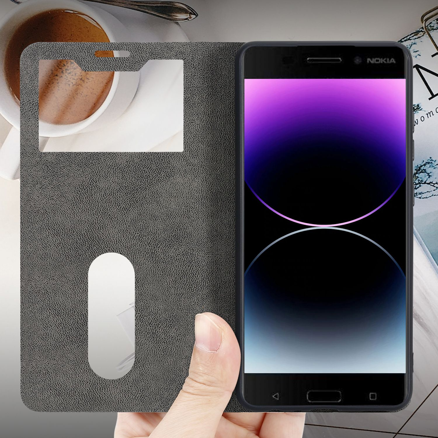 Una persona sostiene una funda de teléfono abierta, mostrando un teléfono y una taza de café.