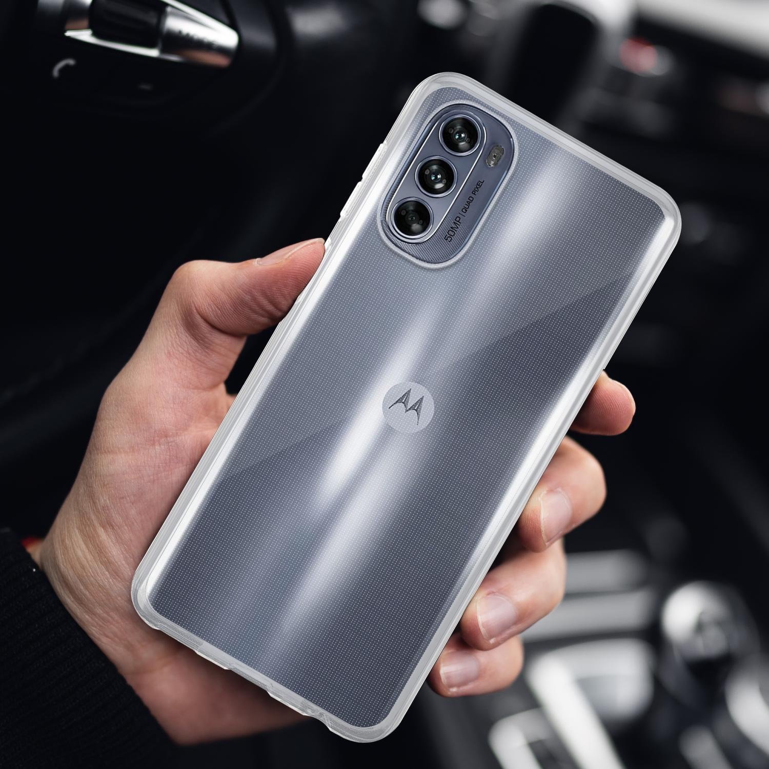 Mano che tiene una custodia trasparente su un telefono con una configurazione a tripla fotocamera.
