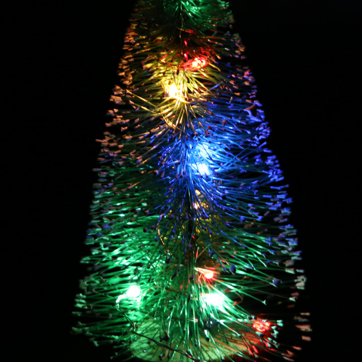 Ein Weihnachtsbaum aus grünen Lichtern. Er hat mehrfarbige LEDs auf schwarzem Hintergrund.