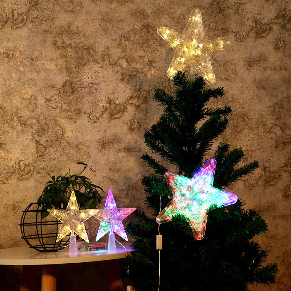Weihnachtsbaum mit Sternlichtern. Drei Sternlichter in verschiedenen Farben. Brauner Wandhintergrund.