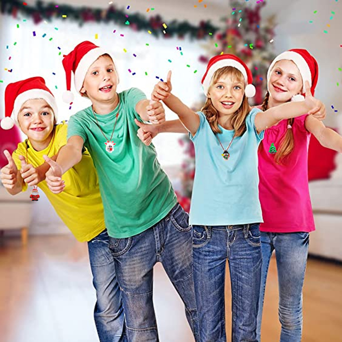 Vier Kinder mit Weihnachtsmützen geben Daumen hoch. Konfetti fällt. Sie tragen weihnachtliche Halsketten und Jeans.
