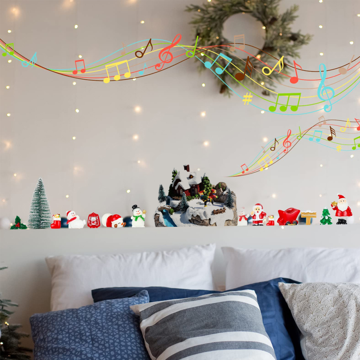 Weihnachtsdekorationen an einer Wand, einschließlich Noten und Figuren, über einem Bett.