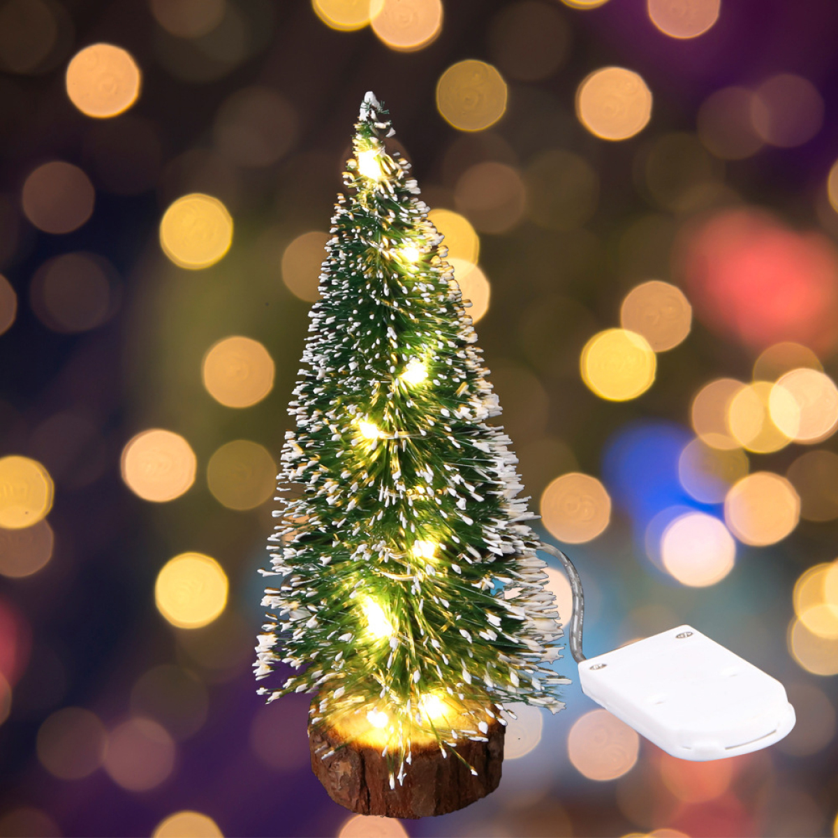 Ein kleiner Weihnachtsbaum mit Lichterketten auf Bokeh-Hintergrund und ein Akku.