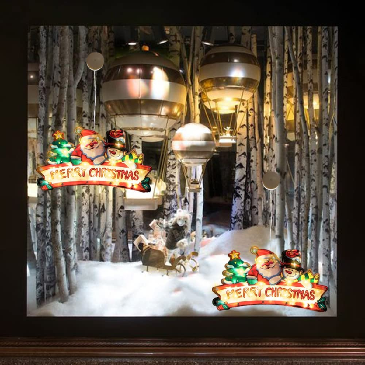 Eine Weihnachtsauslage. Heißluftballons, Weihnachtsmann, Schnee und ein Frohe Weihnachten Banner.