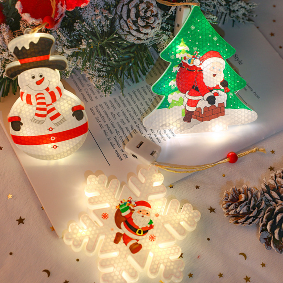 Weihnachtsdekorationen: Schneemann, Weihnachtsmann und Schneeflocke. Alle sind beleuchtet und auf Oberfläche dekoriert.