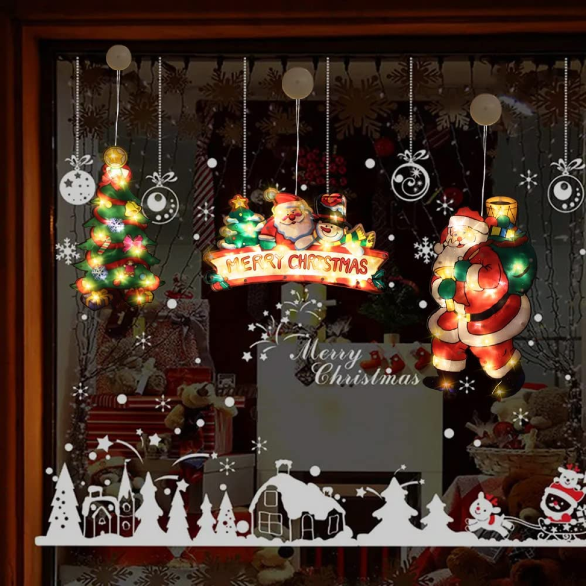 Weihnachtsfenster mit Lichtern, Weihnachtsmann und dekorierten Weihnachtsbäumen.