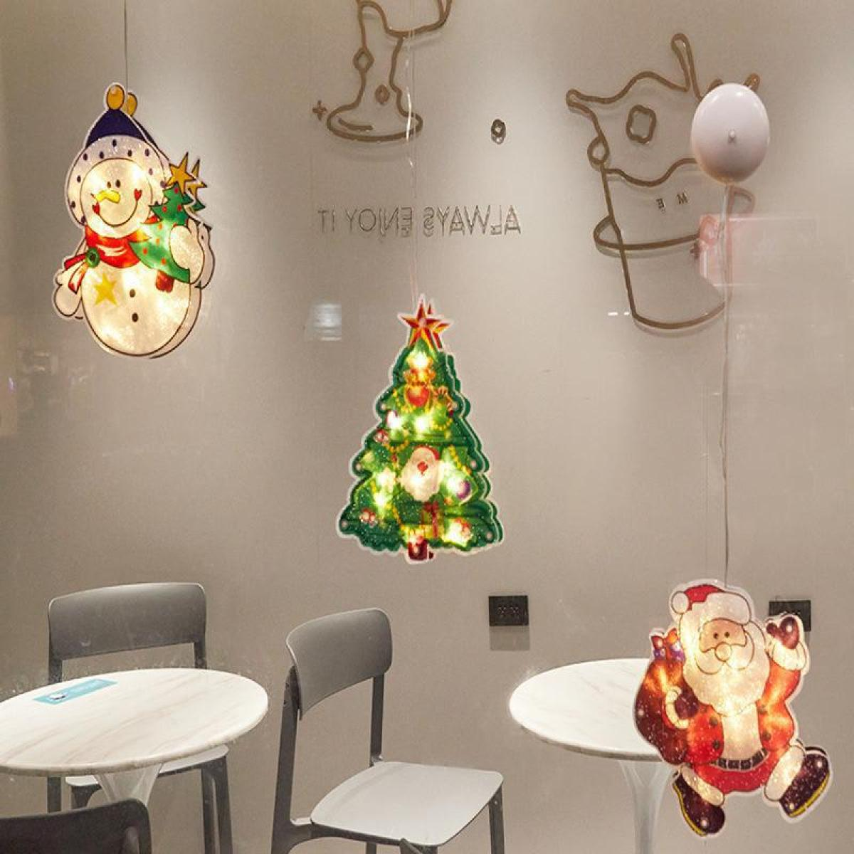 Weihnachtsdekorationen an einem Fenster. Ein Schneemann, ein Weihnachtsbaum und der Weihnachtsmann leuchten.