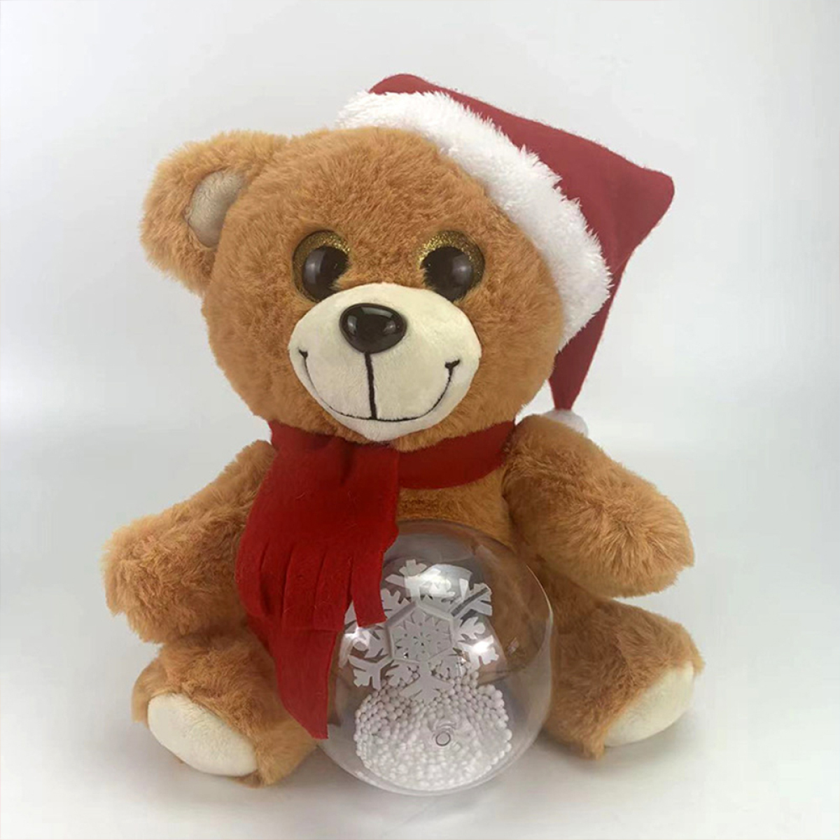 Brauner Teddybär mit Weihnachtsmütze und rotem Schal, hält eine Schneekugel mit Schneeflocken.
