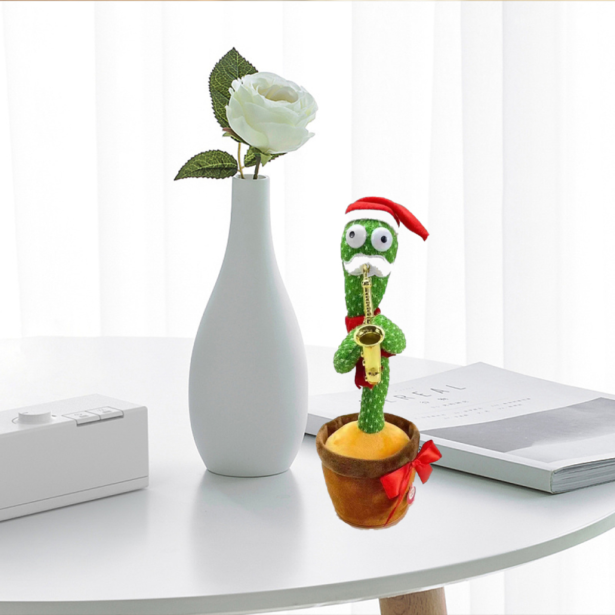 Kaktus mit Weihnachtsmütze spielt Saxophon, neben einer Vase mit weißen Blumen.